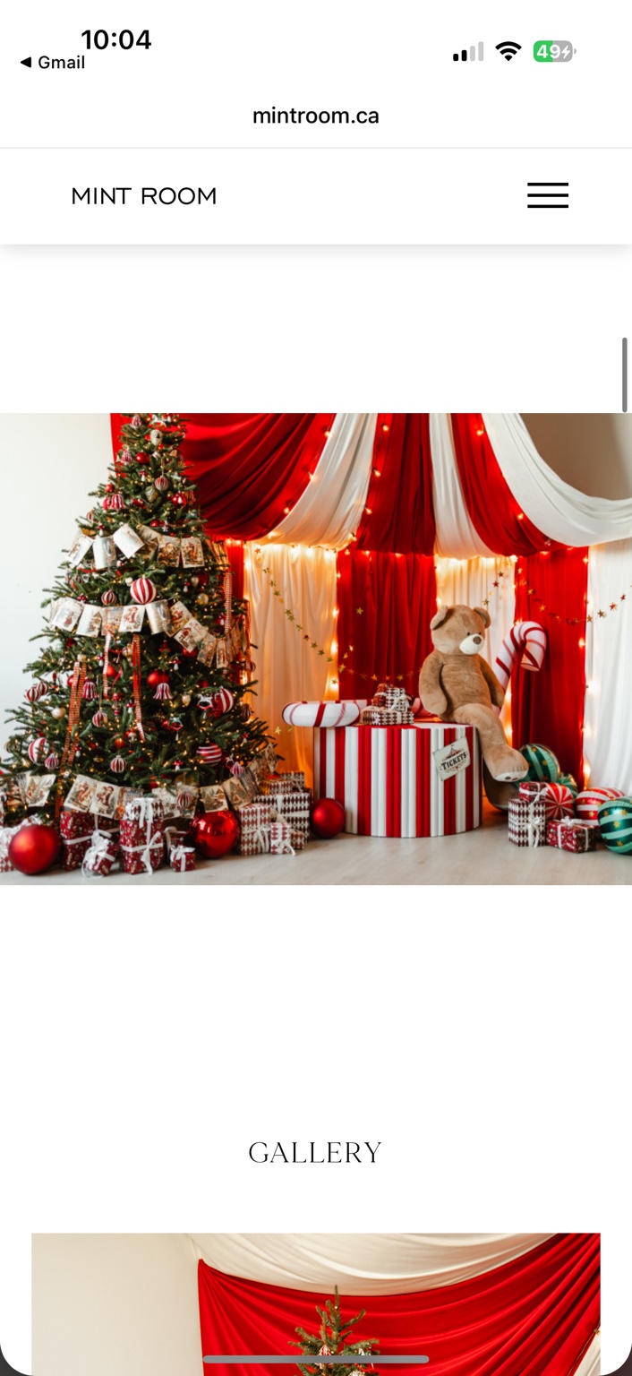 Full landscape view of Vintage Circus with red and cream drapery, a Christmas tree, gifts and a teddy bear